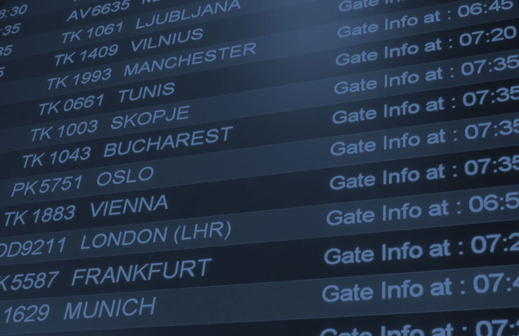 Airport flight departure board showing various destinations.